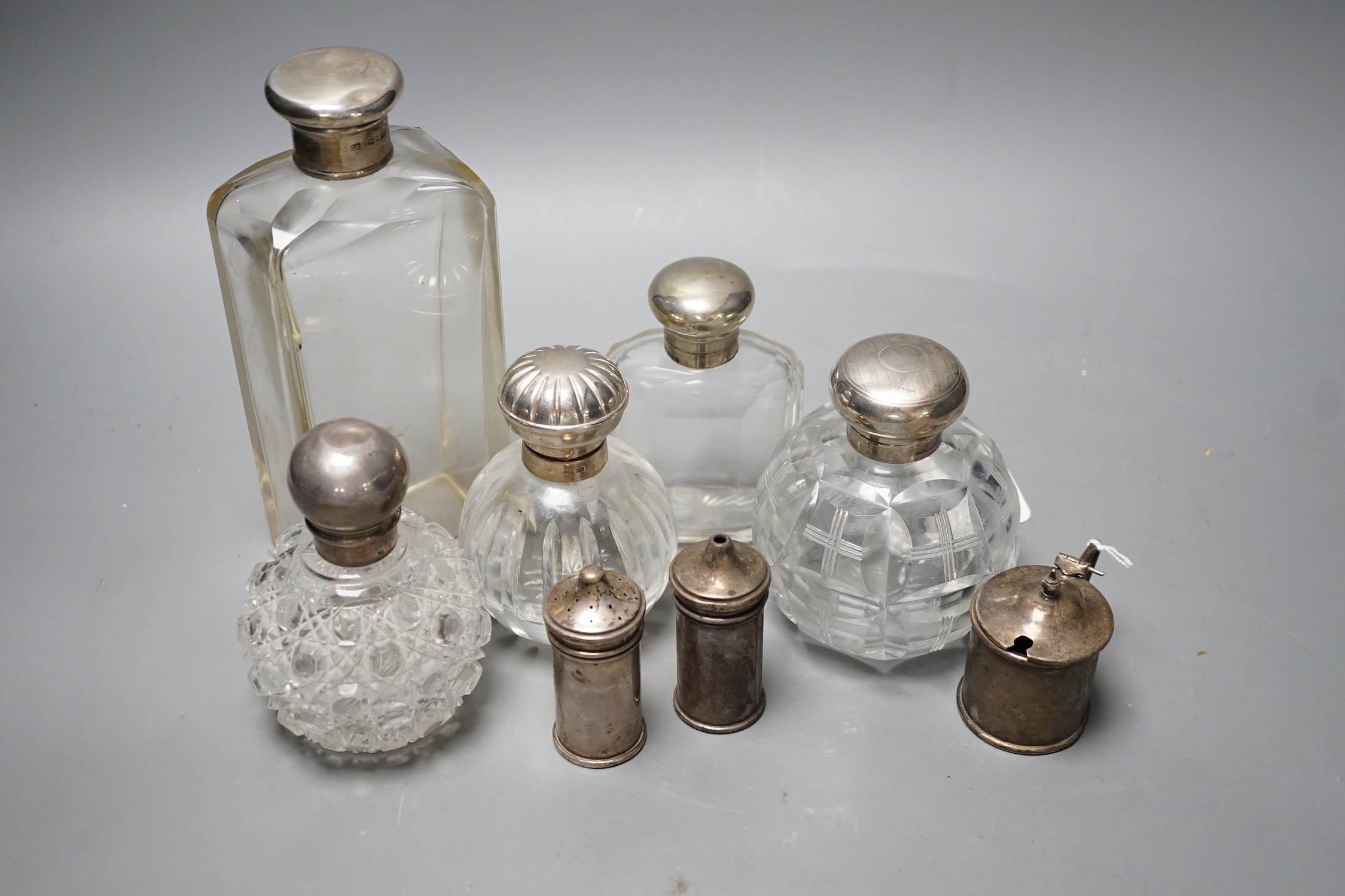 Three silver mounted glass scent bottles, a large silver mounted glass toilet bottle and three silver condiments.